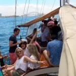 A group enjoying drinks on the deck of a sailing boat on the harbour