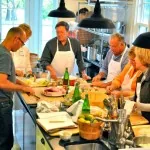 A team in aprons cooking together in a large kitchen