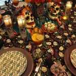 A dinner table set with candles and colourful sugar skull decorations