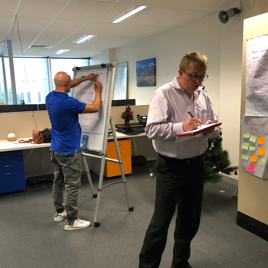 Two managers at a client workplace mapping ideas on a flip chart during an HR Gurus workshop